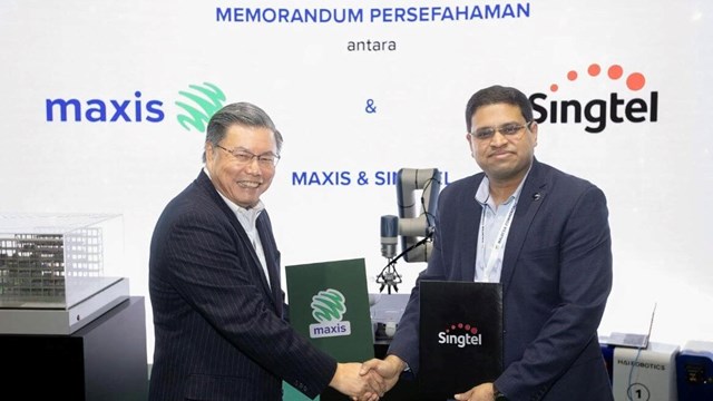 Maxis CEO Goh Seow Eng (left) seals the Paragon deal with Manoj Prasanna Kumar (right), CTO of Singtel Digital InfraCo. 