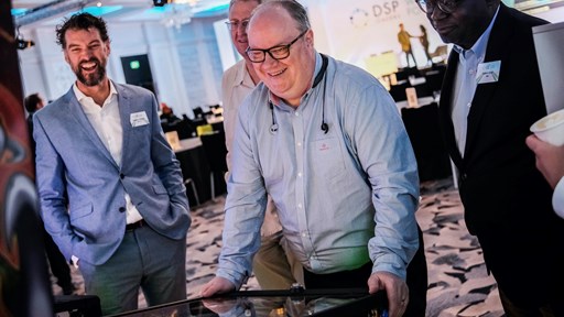 BT's Chief Architect Neil McRae (centre) in action at the charity pinball tournament held at the DSP Leaders World Forum 2022 