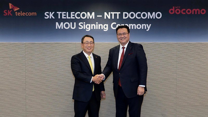 Ryu Young-sang (left), president and CEO of SK Telecom gets to grips with Motoyuki Ii, president and CEO of NTT Docomo.