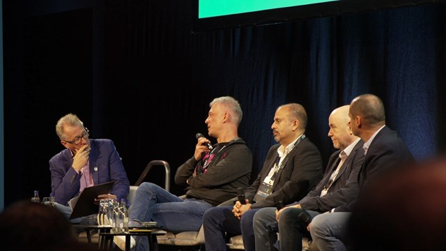 Deutsche Telekom's Thomas Lips (centre with microphone) discusses the telco's Open RAN progress with TelecomTV's Ray Le Maistre at Fyuz 2025 as AT&T's Rob Soni (third from left), Bernard Bureau (second from right) and Vodafone's Paco Martin (far right) listen in. 